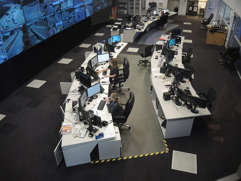 Traffic operations control room with curved desks, monitors and a video wall, seen from above