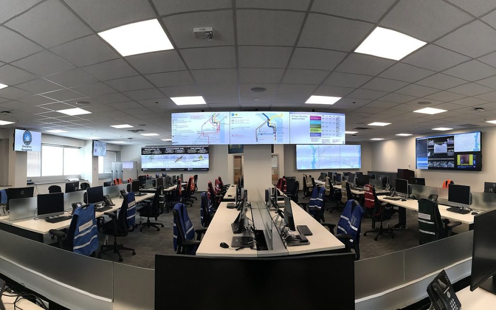 Modern operations center with rows of workstations and large wall-mounted displays