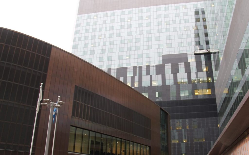 Contemporary glass and metal-clad civic buildings viewed from street level