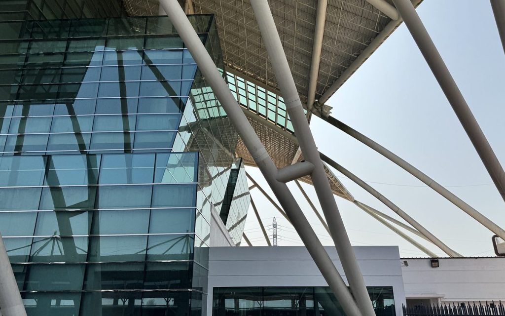 Steel lattice supports framing a glass building facade