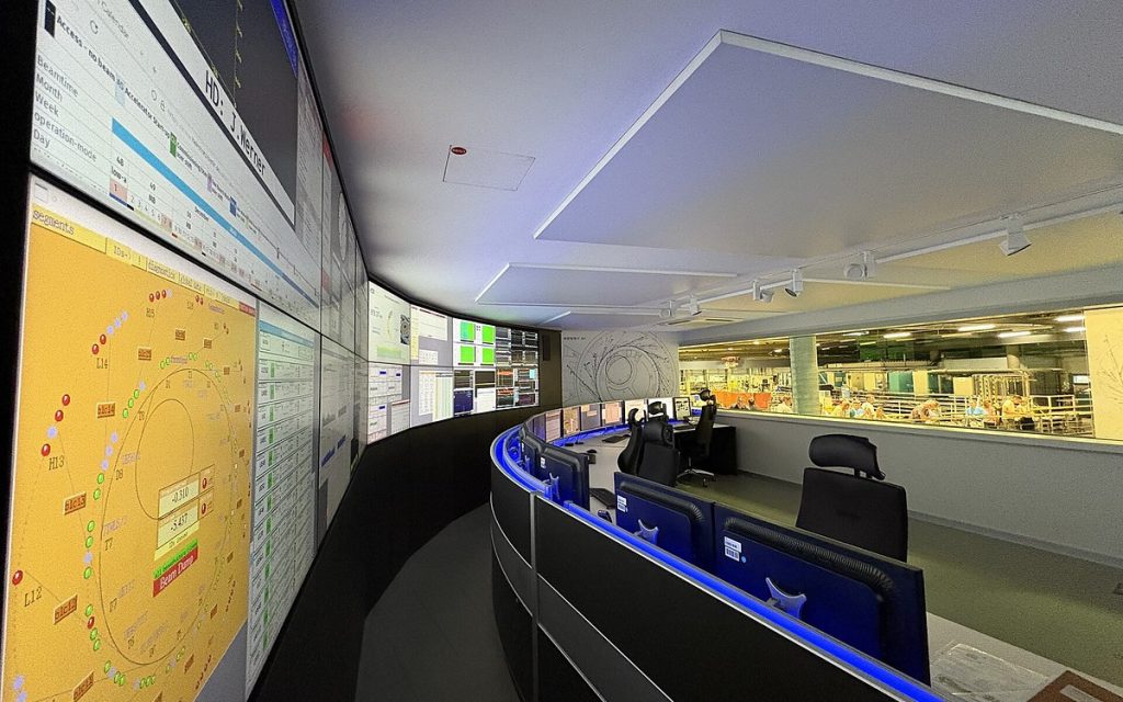 Control room with a long curved wall of displays and a curved operator desk